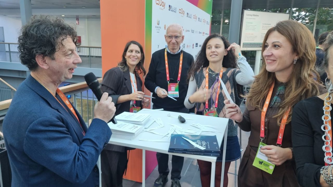 Maurizio Predieri leads the olfactory experience at the Wellbeing Happiness Forum, with participants and scent strips gathered around the table.