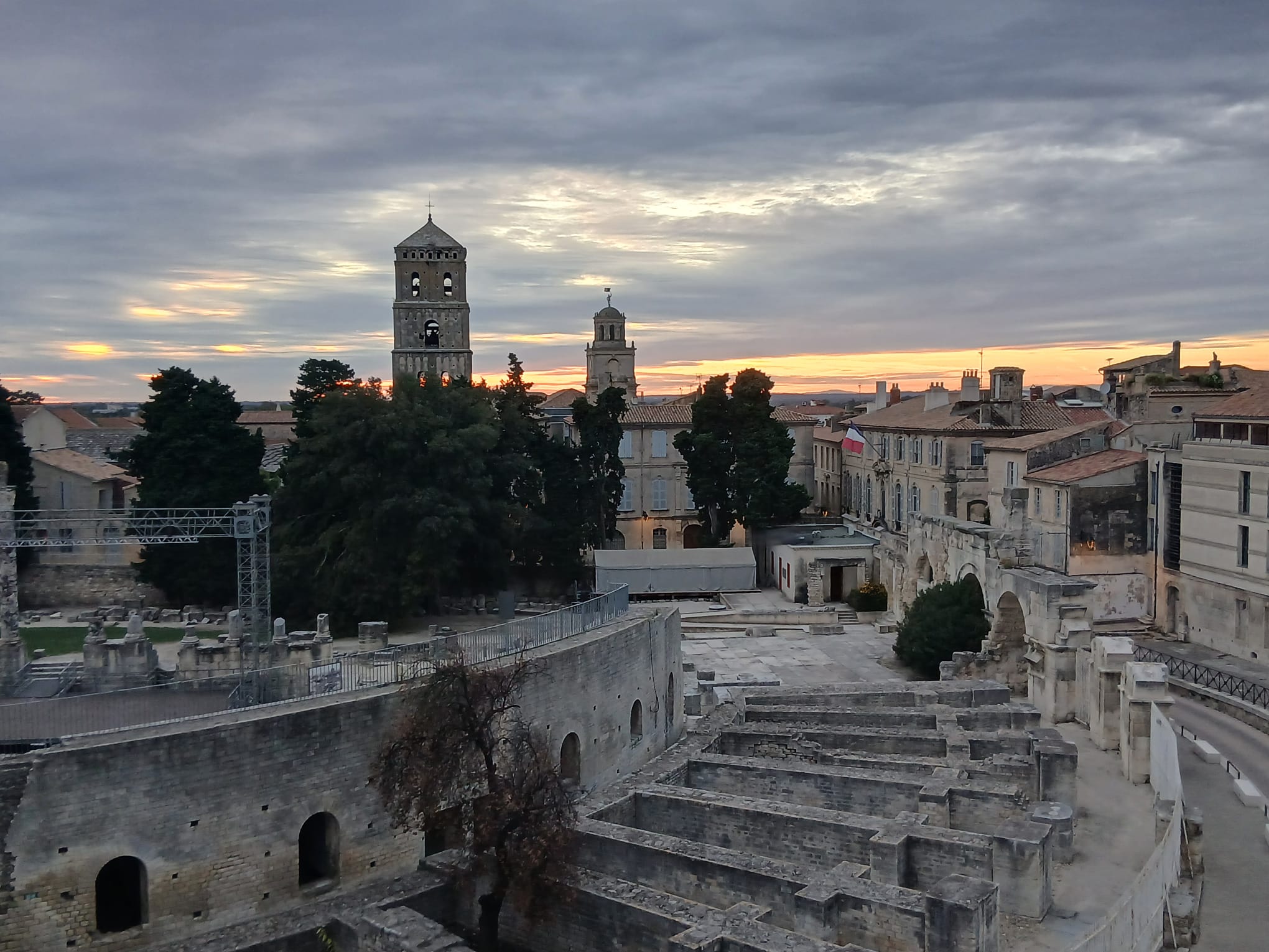 Roofs, towers and ruins in Arles beneath a cloudy sky, photographed from the hotel rooftop.